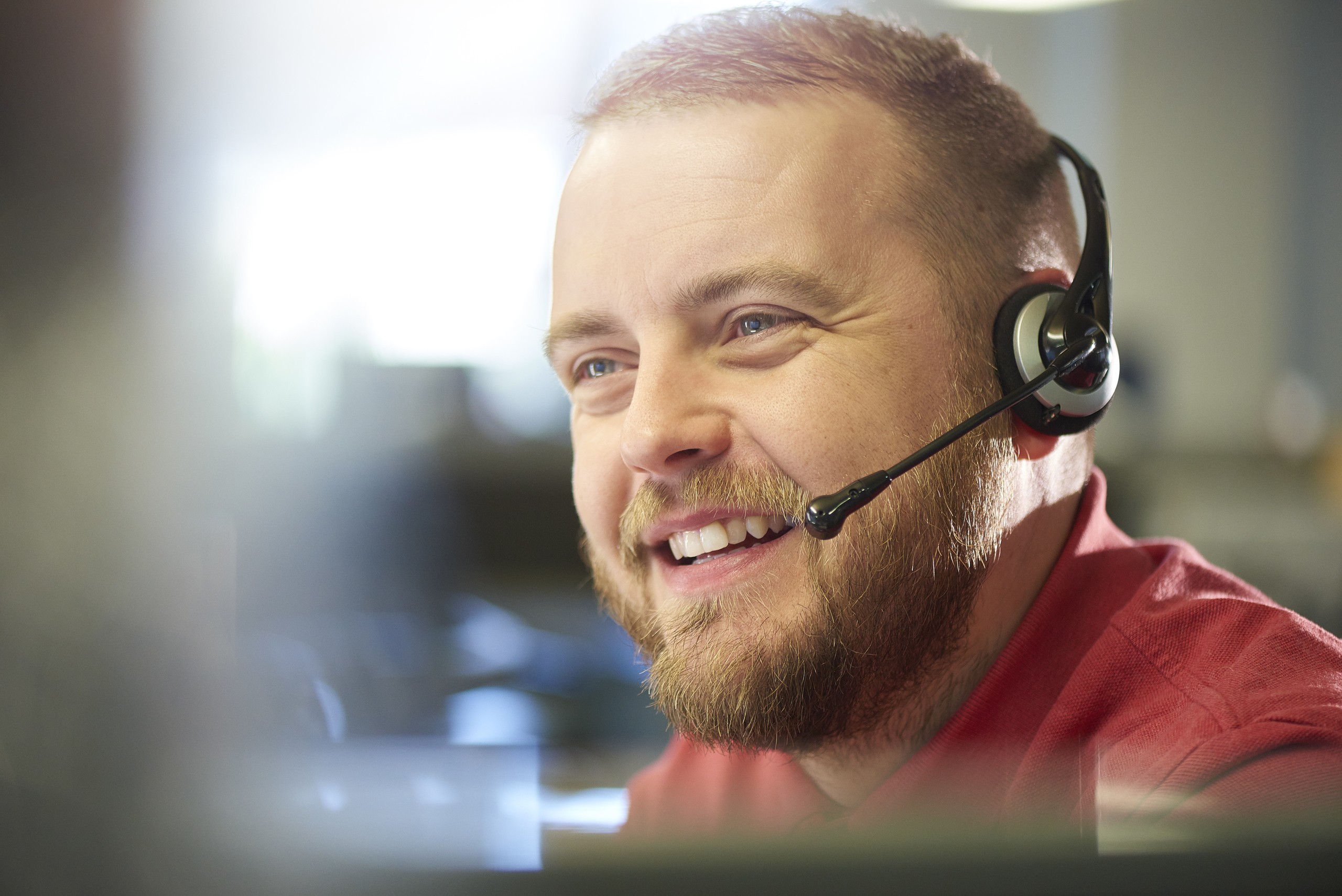 a young male customer services representative on the phone to a customer